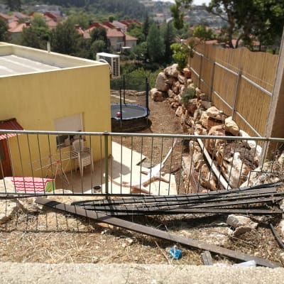 גדר מתכת, צינורות, קרקע עם אבנים לגינון