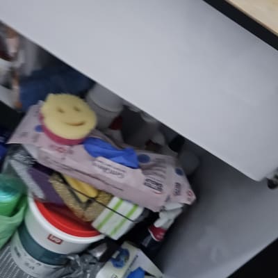 ארון מתחת לכיור עם חומרי ניקוי וכפפות