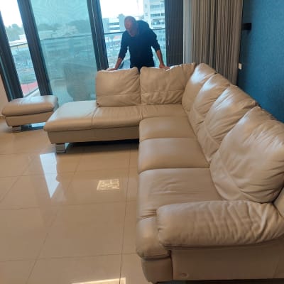 ספה גדולה מעור בצבע בהיר בסלון מואר