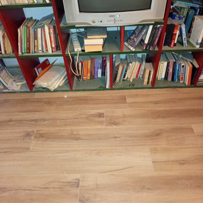 רצפת עץ חדשה ליד מדף ספרים וטלוויזיה ישנה