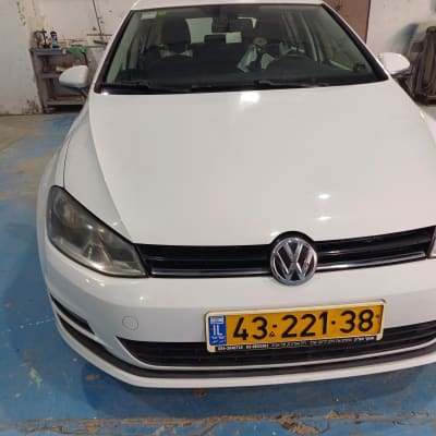 מכונית לבנה עם לוחית רישוי במוסך