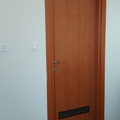 דלת עץ חומה עם ידית מתכת ופתח אוורור