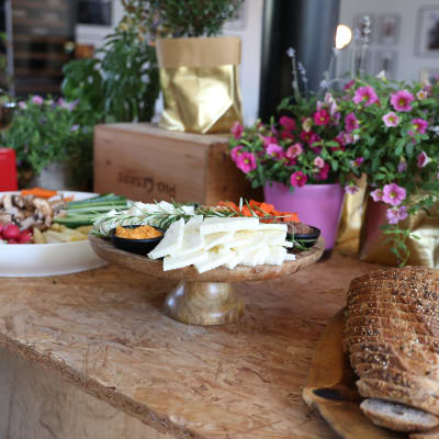 מגש ירקות, גבינות ולחם על שולחן עץ באירוע