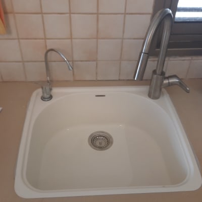 כיור מטבח עם ברזים ומסמכים על השיש