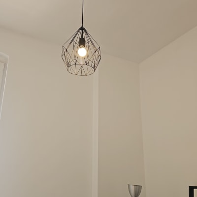 מנורת תקרה עם נורה דולקת בעיצוב גיאומטרי