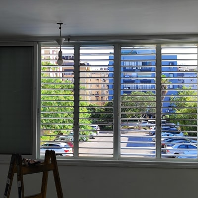 תריסים אופקיים לבנים על חלון גדול