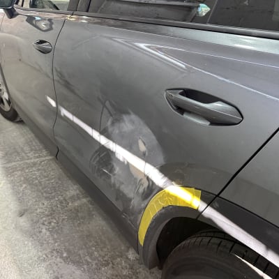 רכב עם סימני תיקון וצבע על הדלת והכנף