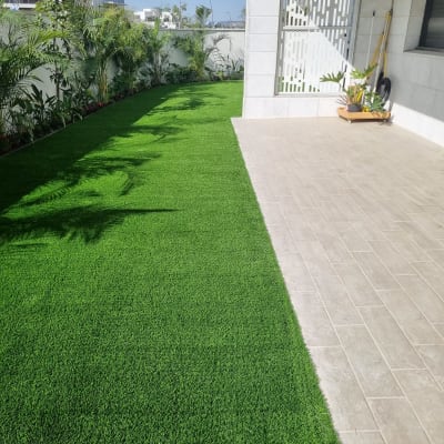 דשא ירוק, עציצים וכלי גינון על מרפסת