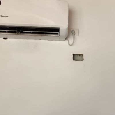 מזגן מותקן על קיר עם חור חשוף