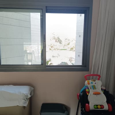 חלון עם תריסים פתוחים וחפצים בחדר