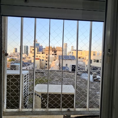 רשת מתכת על חלון למניעת כניסת יונים