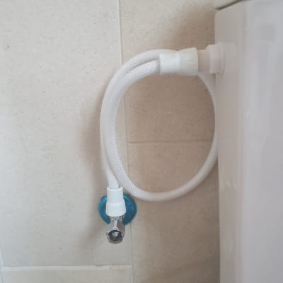 צינור מים מחובר לאסלה על קיר אריחים