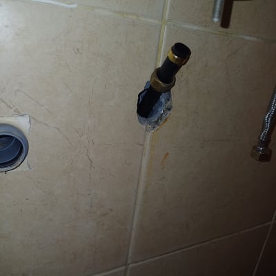 צינור שחור עם מחבר פליז בקיר קרמיקה