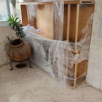 רהיט עטוף בניילון לצד עציץ בפינה