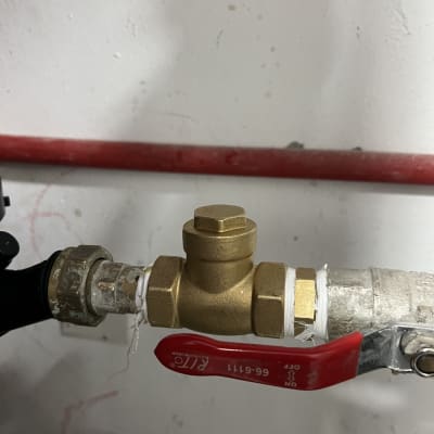 שסתום פליז עם ידית אדומה על צינור