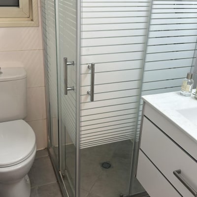 מקלחון זכוכית עם דלתות מתכת בחדר אמבטיה