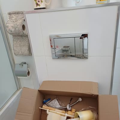 חלקי אינסטלציה בארגז קרטון בחדר אמבטיה