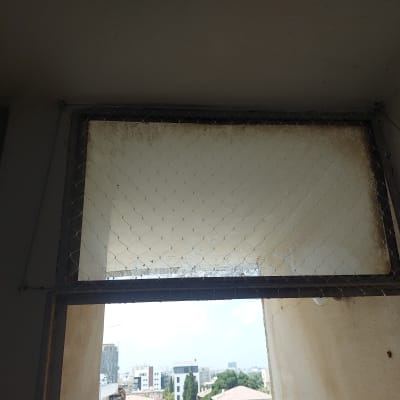 רשת מתכת מותקנת על חלון למניעת כניסת יונים