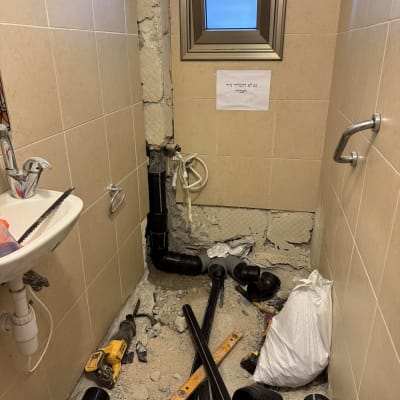 עבודת אינסטלציה עם צינורות וכלים בחדר אמבטיה