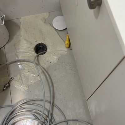 פתיחת סתימה בפתח ניקוז ברצפת חדר רחצה באמצעות קפיץ אינסטלציה