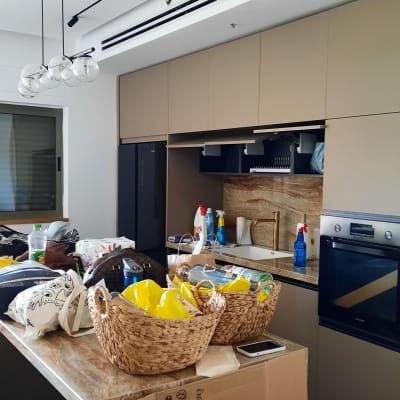 מטבח עם ארגזים, סלסלות וציוד ניקוי על השיש