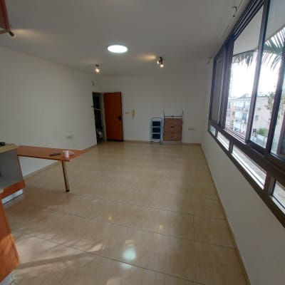 חדר ריק עם רצפה נקייה ומגב בפינה