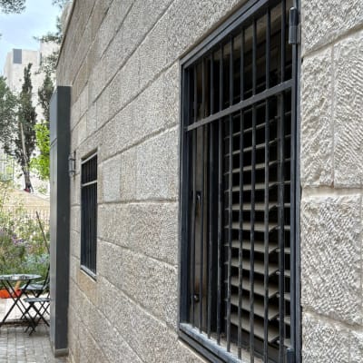 קיר אבן עם חלונות מסורגים בחוץ