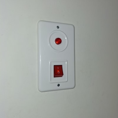 מתג חשמלי עם נורית חיווי על קיר