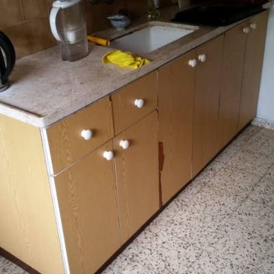 ארונות מטבח עם קומקום חשמלי ומטלית צהובה