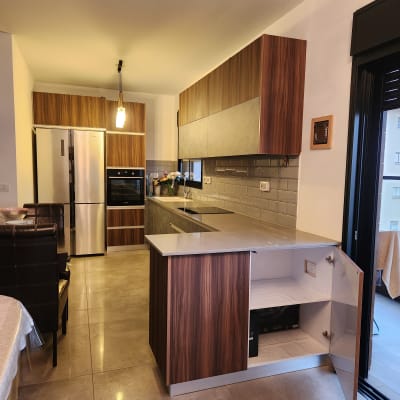 מטבח מודרני עם ארונות עץ, מקרר ותנור