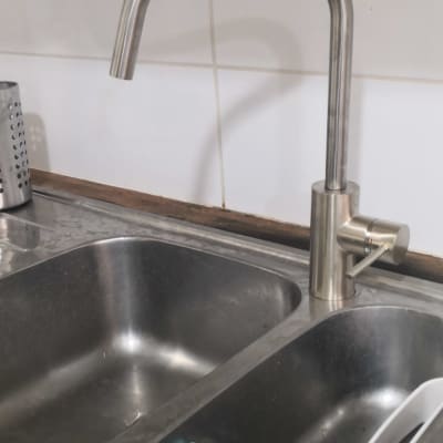 ברז נירוסטה מעל כיור כפול עם כלי עבודה כחול