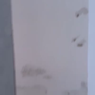 קיר לבן עם חורים וסימני פגיעה הדורש סתימת חורים ותיקון