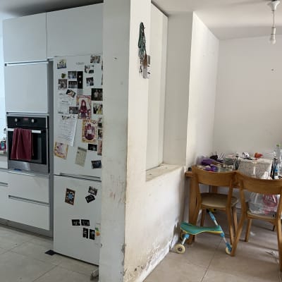 קיר עם סימני לכלוך וציוד צביעה על שולחן