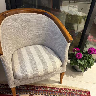 כיסא מרופד ליד שטיח ופרחים