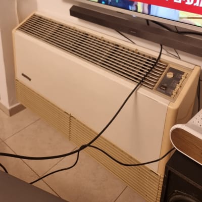 מזגן ישן עם כבלים מחוברים על הרצפה