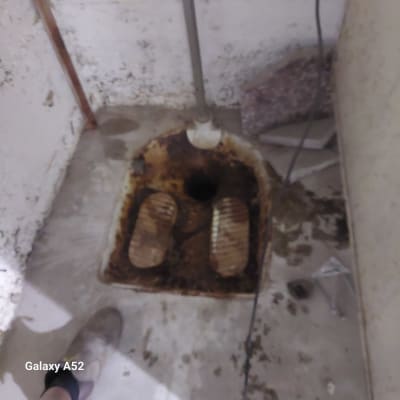 אסלה מזרחית עם צינור מים וחלודה