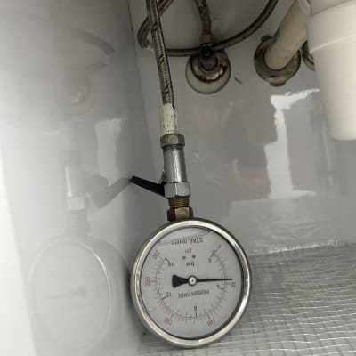 מד לחץ מים מתחת לכיור עם צינורות