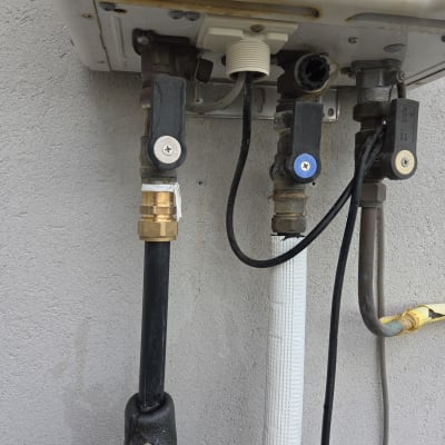 צנרת ומחברים במערכת חימום מים על קיר חיצוני