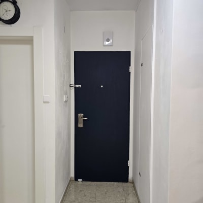 דלת כהה עם ידית מתכת בקיר לבן