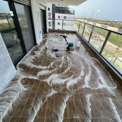 מרפסת עם רצפה רטובה, מכונת ניקוי ודלי