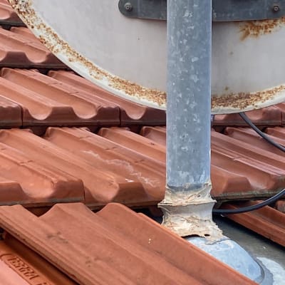 צלחת לוויין על גג רעפים אדומים עם חלודה