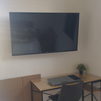 טלוויזיה מותקנת על קיר מעל שולחן עבודה