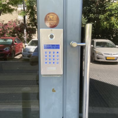 מערכת אינטרקום על דלת זכוכית עם מדבקה