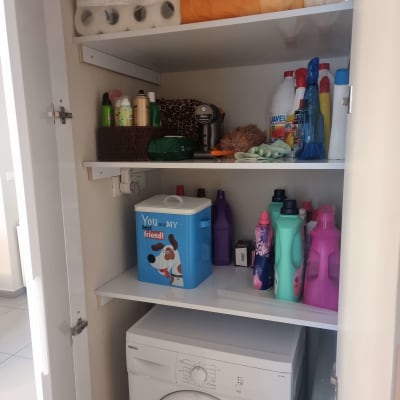 ארון עם מדפים, מוצרי ניקוי ומכונת כביסה