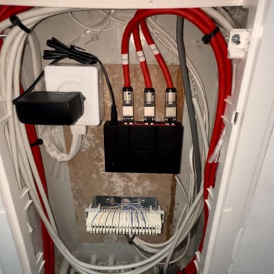 כבלים אדומים ולבנים מחוברים למפצל רשת בארון תקשורת