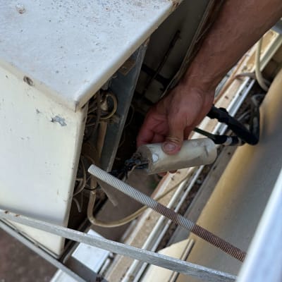 יד מחזיקה חלק ממזגן חיצוני
