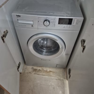 מכונת כביסה אפורה עם כפתורי שליטה ותצוגה דיגיטלית