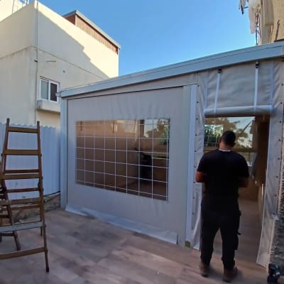 אדם מתקין סוכך בחצר עם סולם