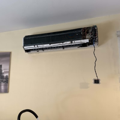 מזגן מפורק על קיר עם סולם לידו