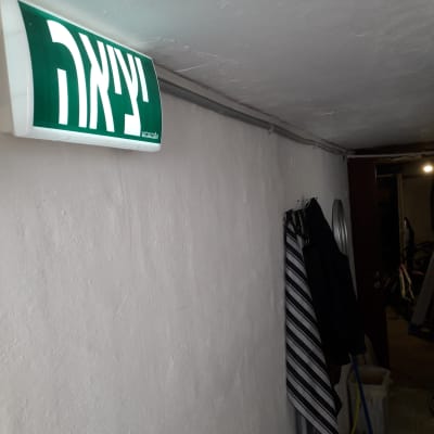 שלט יציאה מואר על קיר לבן